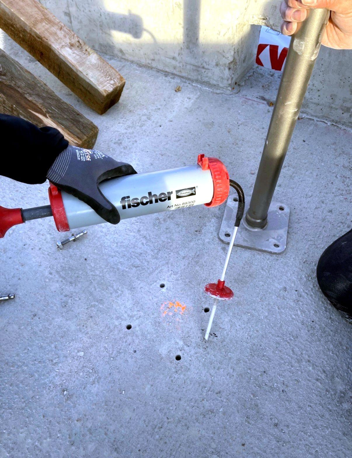Ausblasen von Bohrlöchern in Beton vor dem Setzen eines Dübels für ein ABS-System