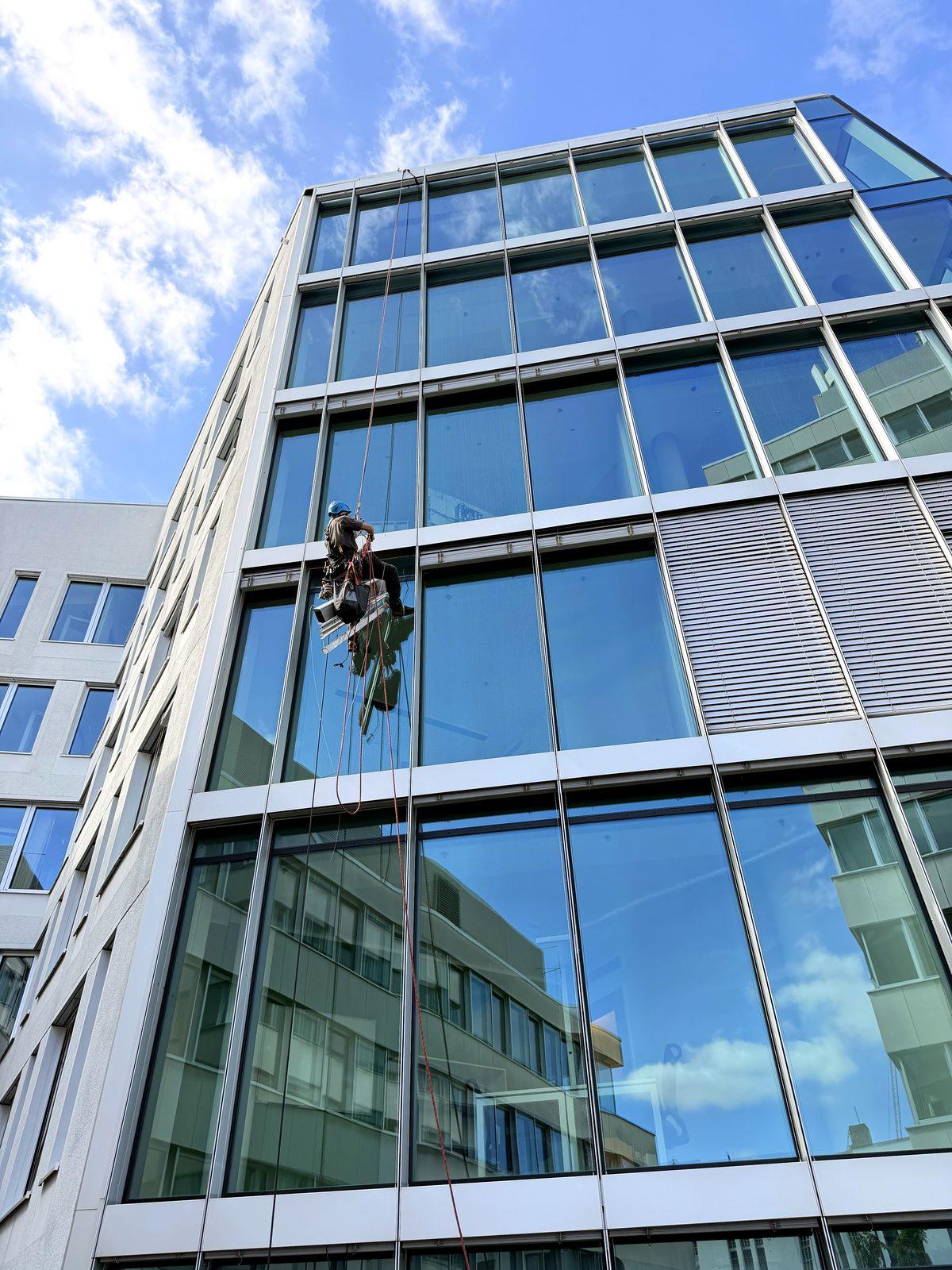 Kletterer per Seilzugang beim Ausbau einer Außenjalousie an einem Hochhaus
